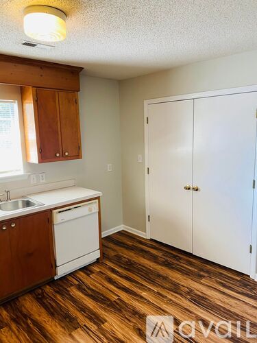 A kitchen with white appliances and wooden cabinets.