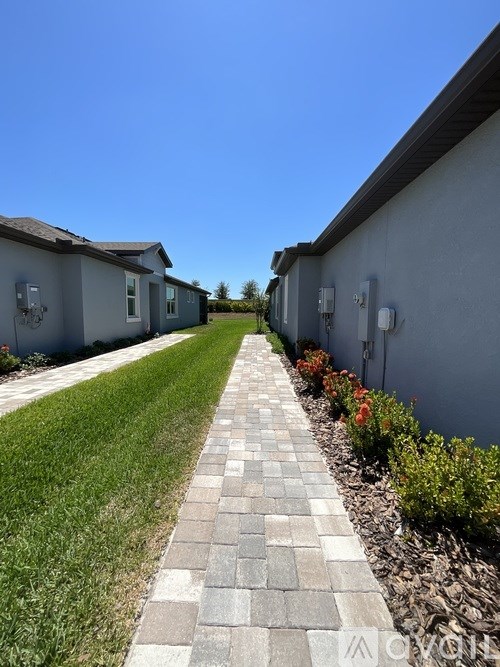 A long brick pathway leads between two rows of houses.