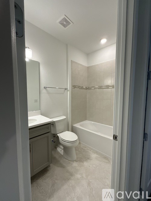 A bathroom with a toilet, sink, and bathtub.