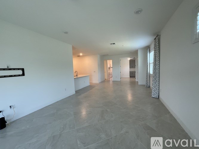 A spacious room with marble flooring and white walls.