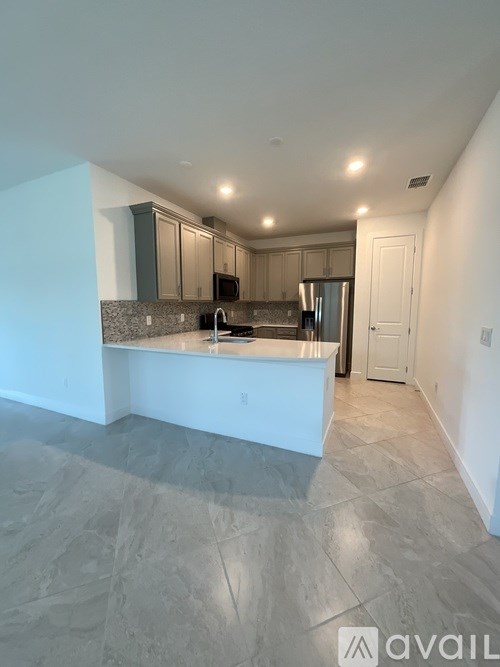A kitchen with a marble floor and a white island.
