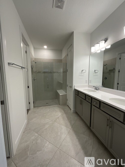 A bathroom with a walk-in shower and double sinks.