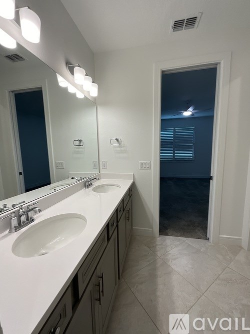A bathroom with two sinks and a large mirror.