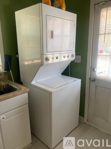 A white oven with a microwave on top is in a kitchen.