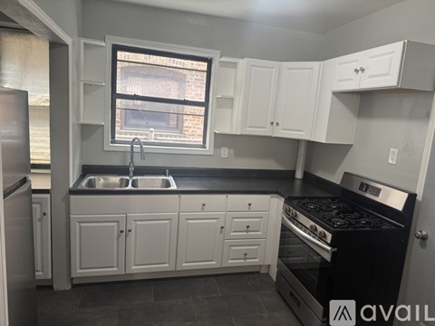 A kitchen with white cabinets and a black stove top oven.