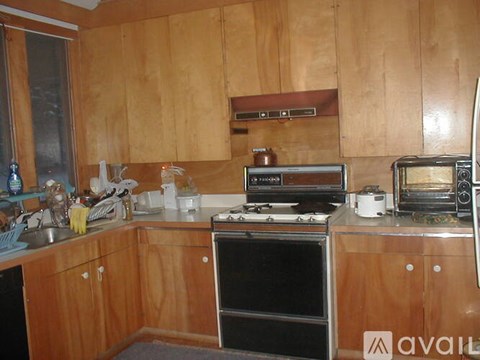 A kitchen with wooden cabinets and a black oven.