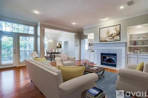 A living room with a fireplace and a painting on the wall.