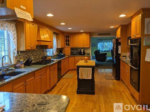 A kitchen with wooden cabinets and a marble countertop.