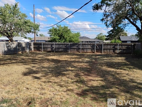 A backyard with a fence and trees.