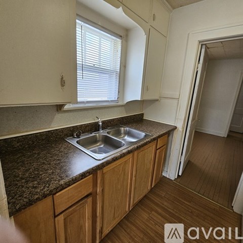 A kitchen with a sink and wooden cabinets.