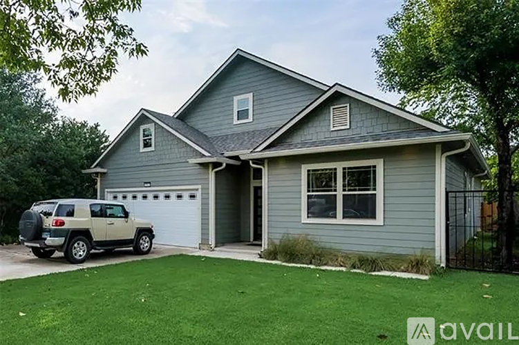 A house with a garage and a car parked in front.