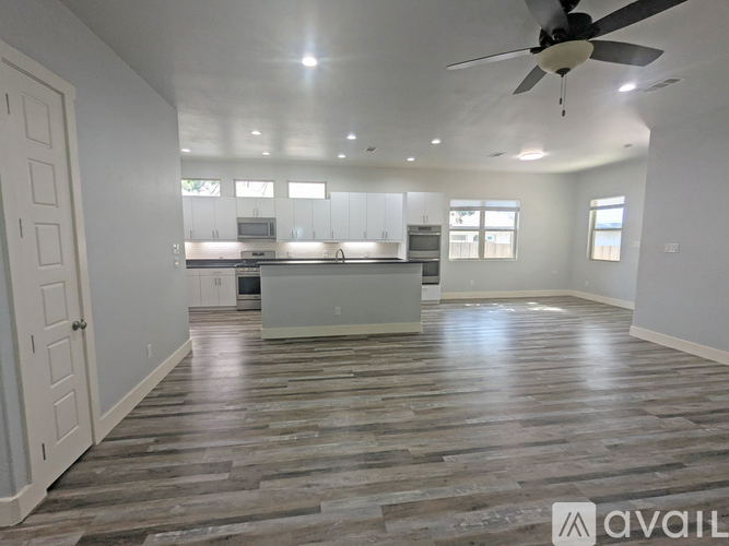A kitchen with white cabinets and black countertops.