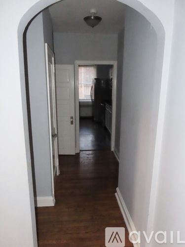 A hallway with a white door and a brown floor.