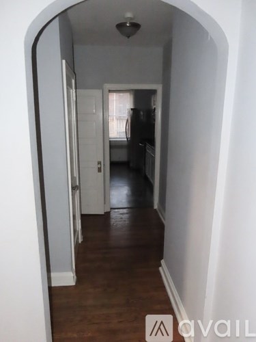A hallway with a white door and a brown floor.