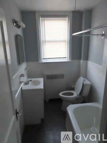 A small bathroom with a toilet, sink, and bathtub.