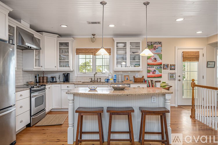 A kitchen with white cabinets and a marble countertop.