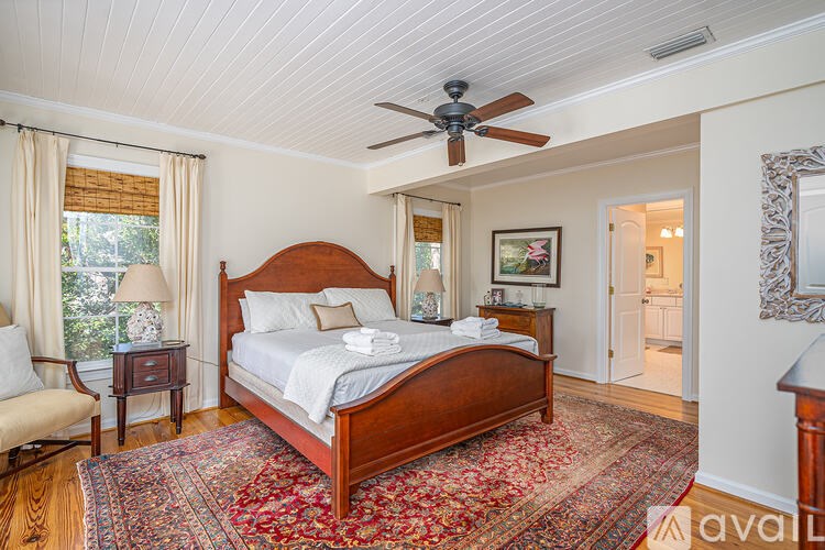 A bedroom with a large bed and a ceiling fan.