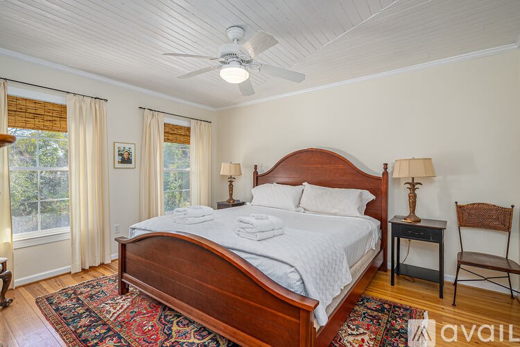 A bedroom with a large bed and a ceiling fan.