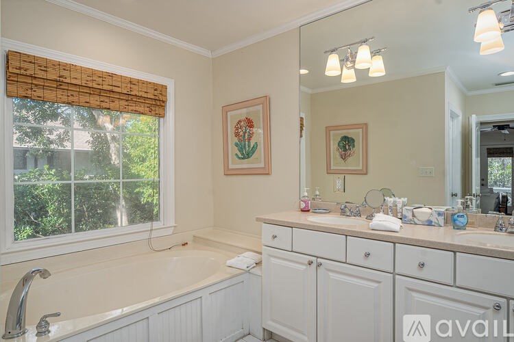 A bathroom with a large tub and a window with blinds.