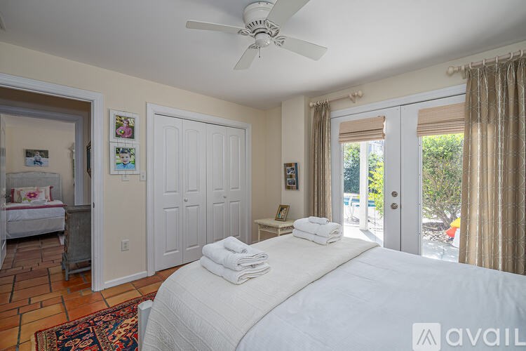 A bedroom with a large bed and a ceiling fan.