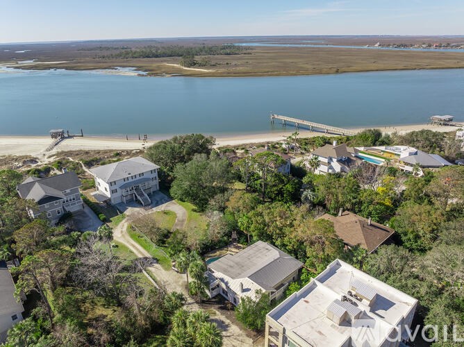 A bird's eye view of a residential area with houses and a pier extending into the water.
