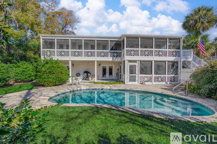A house with a pool in front of it.