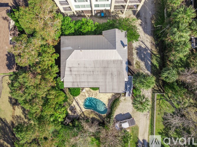 A house with a pool surrounded by trees.