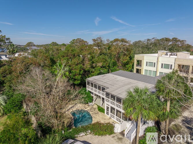 A house with a grey roof is surrounded by trees.