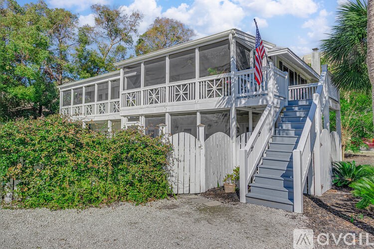 A white house with a flag on the balcony.