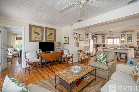 A living room with a wooden floor and furniture.
