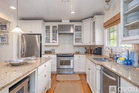 A kitchen with white cabinets and a granite countertop.