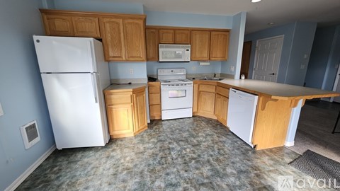 A kitchen with a white refrigerator, white oven, and white dishwasher.