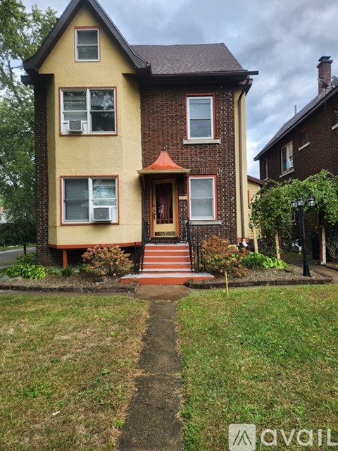 A two-story house with a red door and a small porch.
