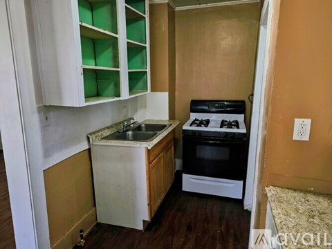 A kitchen with a white counter top and a black stove top oven.