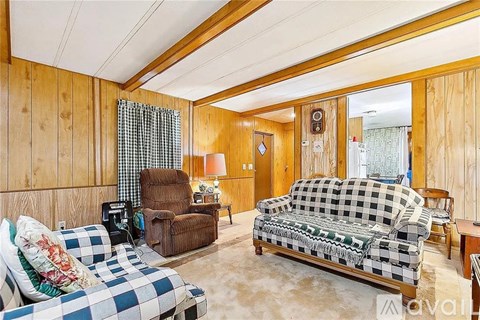 A living room with a checkered couch and a chair.