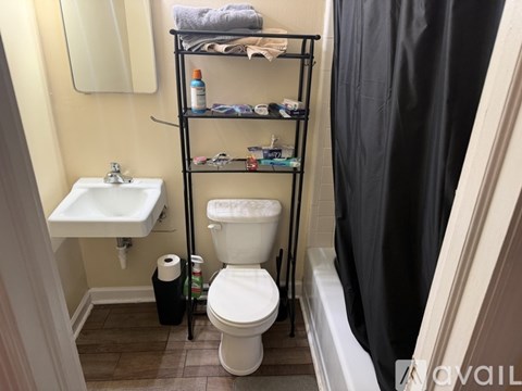 A bathroom with a toilet, sink, and shelves.