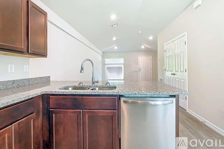 A kitchen with brown cabinets and a granite countertop.