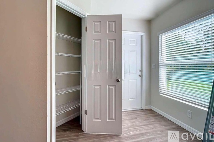 A white door is open to a room with a white door and window.