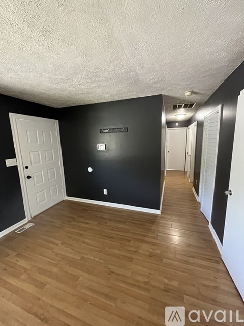 A room with wooden flooring and a white door.