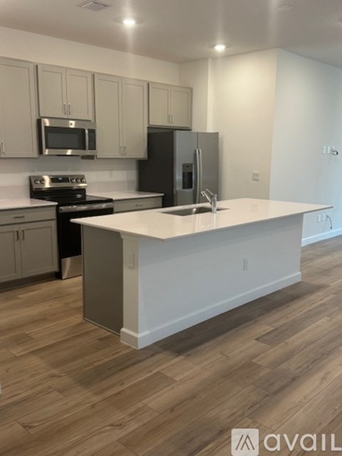 A kitchen with a white island and wooden floors.