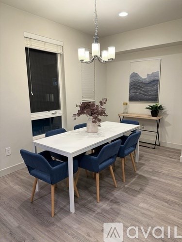 A dining room with a white table and blue chairs.