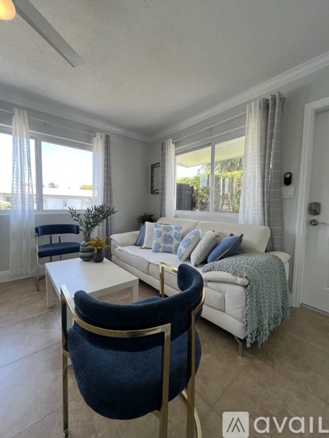 A living room with a white couch and a blue chair.