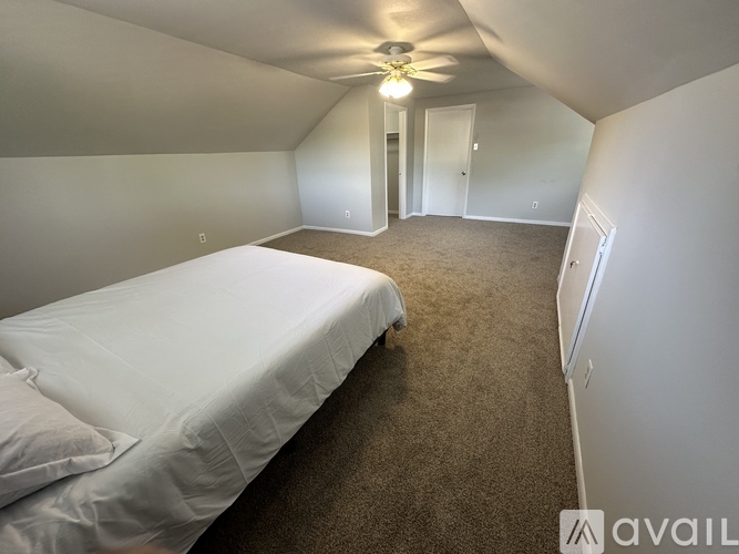 A room with a white cabinet and a doorway leading to another room.