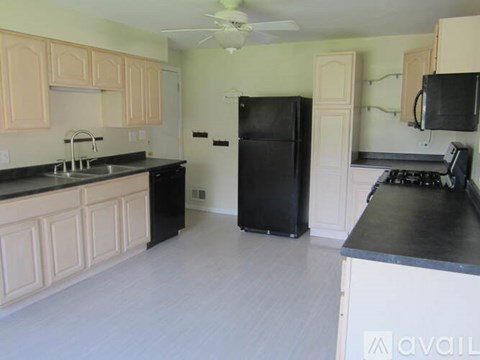 A kitchen with black appliances and white cabinets.