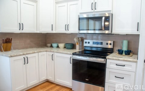A kitchen with white cabinets and a black stove top oven.