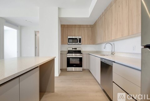 A kitchen with a stainless steel dishwasher and a microwave above the stove.