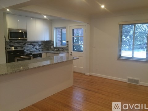 A kitchen with a granite countertop and stainless steel appliances.