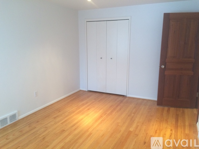 A room with a white door and a wooden door.