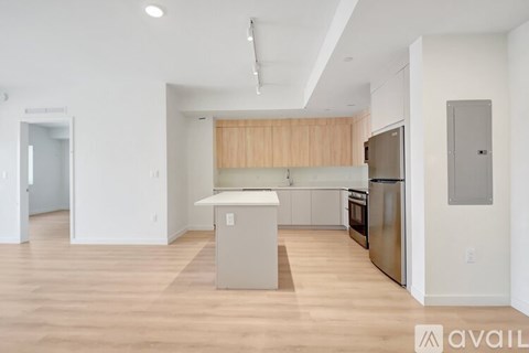 A kitchen with wooden cabinets and a refrigerator.
