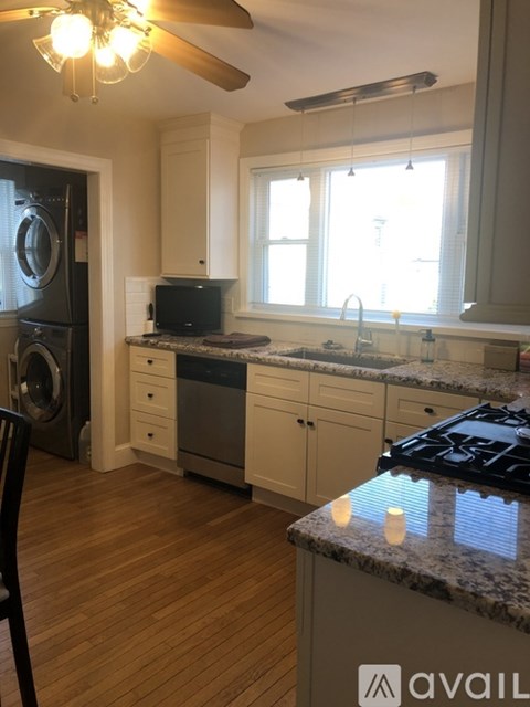 A kitchen with a black stove top and wooden floors.
